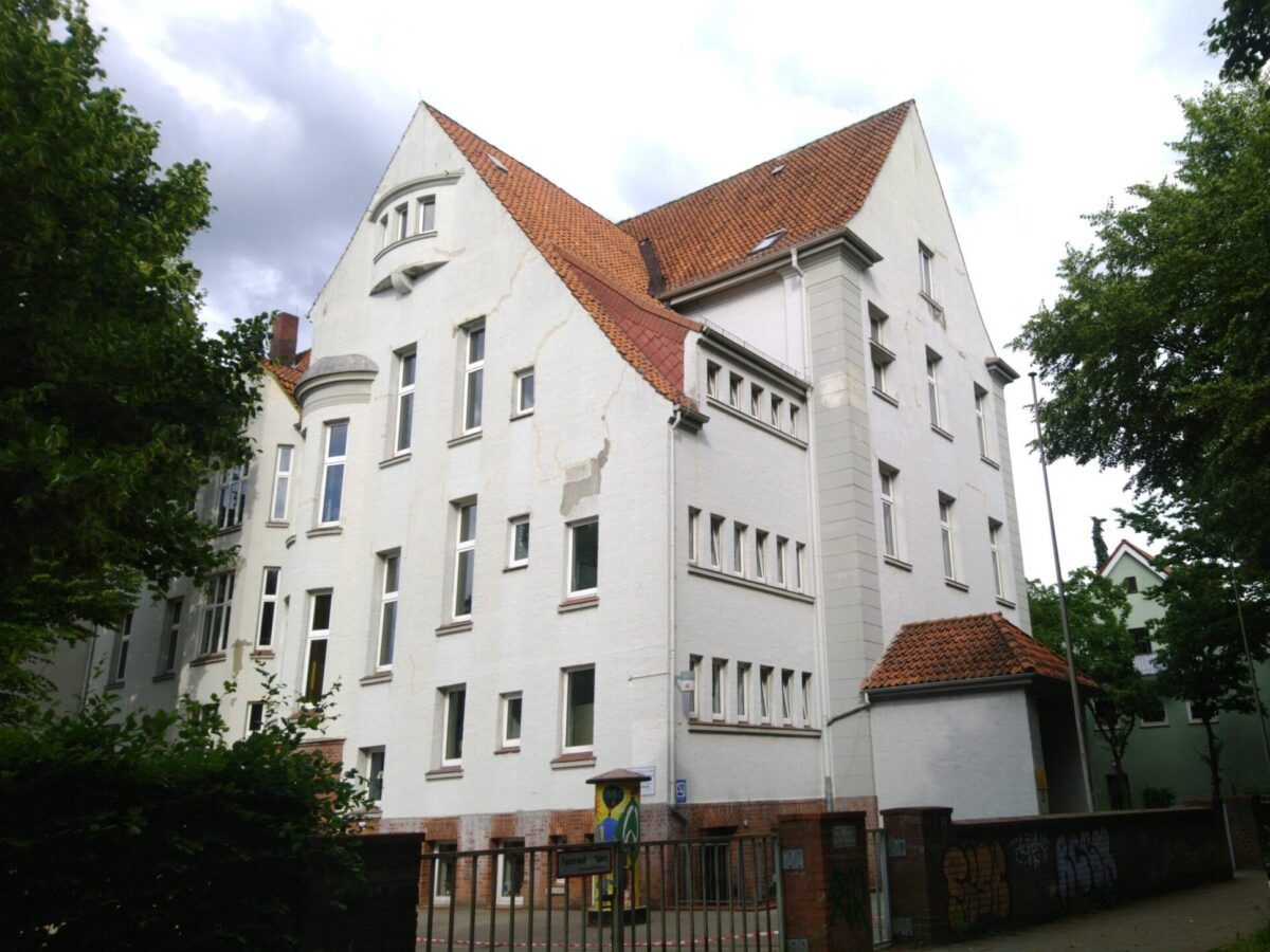 Das Schulgebäude am Alten Postweg. An der Fassade sind deutliche Risse zu sehen.